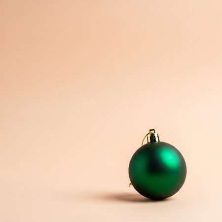 Green christmas ball on a beige background with copy space.の素材