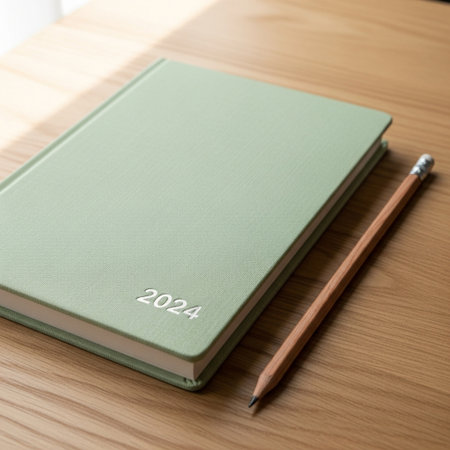 Green book with pencil on the wooden table, new year concept.の素材