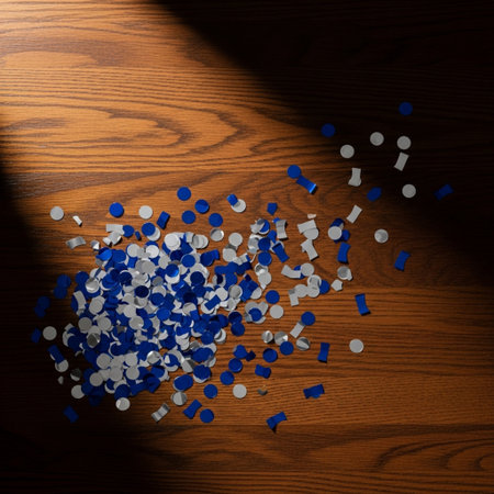 Pile of blue and white confetti falling on a wooden backgroundの素材
