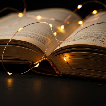Open book with glowing christmas lights on dark background. Shallow depth of fieldの素材