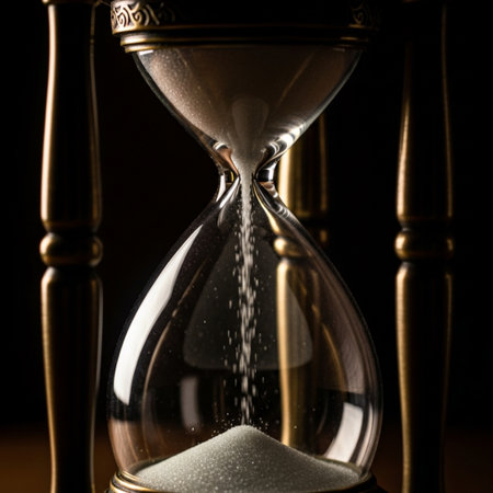 Hourglass on dark background. Time concept. Sand running through the glass.の素材