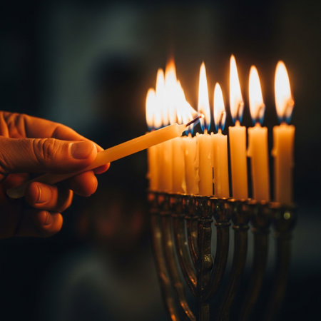 Hand lighting a candle in the Jewish Chanukah menorah.の素材