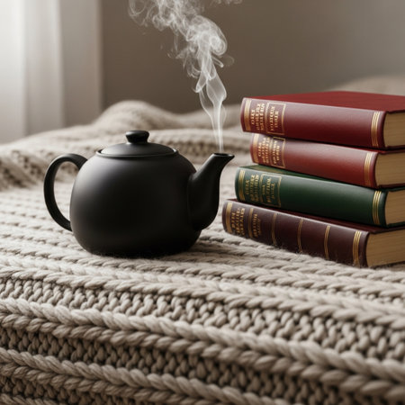 Teapot and books on a knitted plaid in the roomの素材