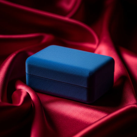 Blue gift box on red satin background. Shallow depth of fieldの素材