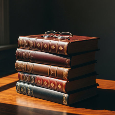 Stack of old books with eyeglasses on the wooden table.の素材