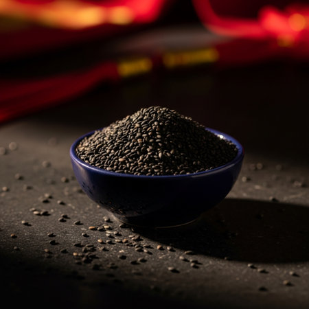 Black sesame seeds in a blue bowl on a black background.の素材