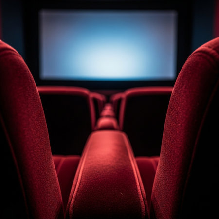 Interior of cinema auditorium with red seats and blank screen.の素材