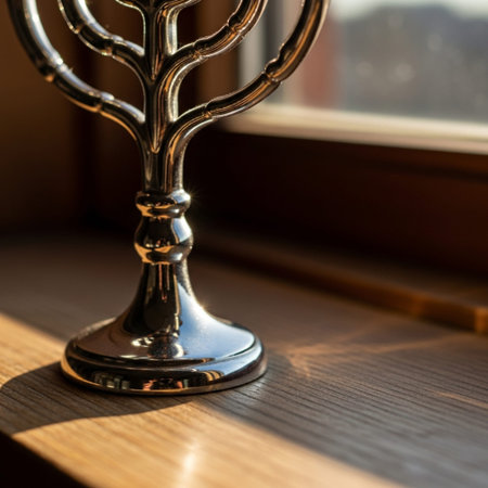 Silver menorah on a wooden table in front of the window.の素材