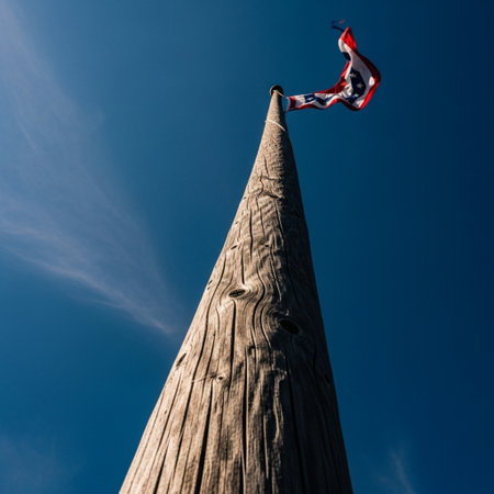 American flag on the top of a wooden pole against the blue skyの素材