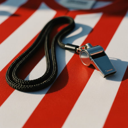 Referee whistle on a red and white striped background. Close-up.の素材
