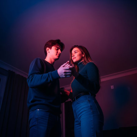 Young couple in love dancing at home on a dark background. Valentine's Day.の素材