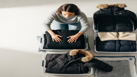 High angle, top-down perspective of a woman performing seasonal organization. She is actively sortinの素材