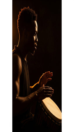 A striking, vertically framed silhouette of a musician intensely playing a traditional African percuの素材