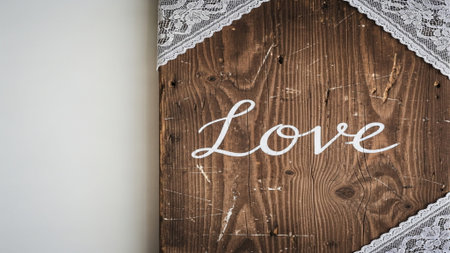 A wide-angle, cinematic photograph of a highly textured, rustic wooden sign reading 'Love' in whiteの素材