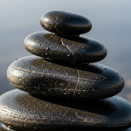 Focus is on the intricate textural detail of a three-stone balanced stack, emphasizing the smooth, wの素材