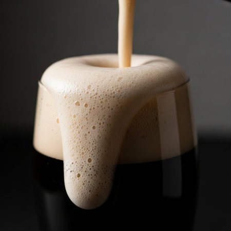 A hero detail shot capturing the texture and symmetry of the thick, creamy head of a stout beer, cenの素材