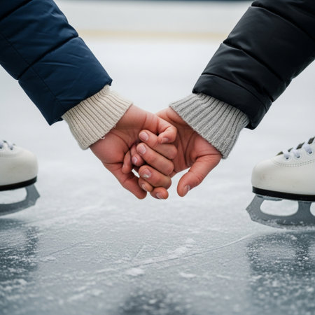 A Hero Detail shot focusing on the intimately intertwined hands of a heterosexual couple ice skatingの素材
