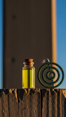 A vertical, tall 9:16 editorial image showcasing a small bottle of yellow citronella oil and an unliの素材