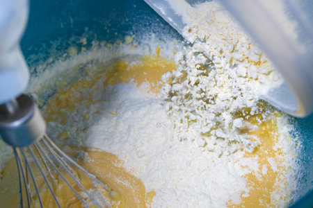 Adding flour to mounted egg to make sponge cake.の写真素材