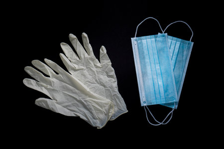 Gloves and masks for protection against viruses on black backgroundの写真素材