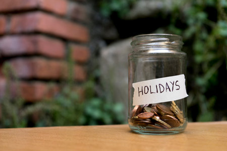 A glass jar with coins inside labeledの写真素材
