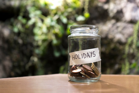A glass jar with coins inside labeledの写真素材