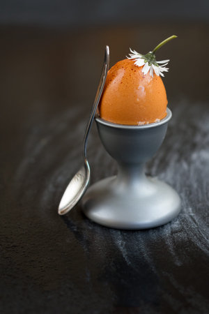 Brown eggs in a cup on a black background