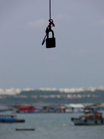 Lock hanging from tree.  Looks like you need a key to enter into the travel world.の写真素材