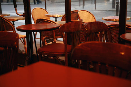 close up of restaurant tables and chairs,  table and chairs are set up indoors and outside on the side walkの写真素材
