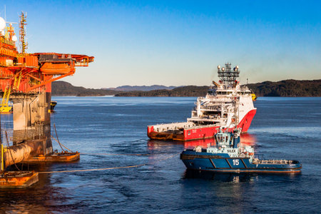 BERGEN, NORWAY - 2014 OCTOBER 16. Offshore vessel Siem Topaz and tugboat Silex under anchor handling operation alongside the semi-submersible drilling rig West Alphaのeditorial素材