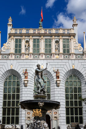 GDANSK, POLEN - 2017 AUGUST 24. Neptune Fountain Statue on Market Street (Dlugi Targ) with the historical buildings Artus Court and city flag of Gdansk behind the statue.のeditorial素材