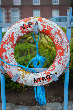 MONTROSE, SCOTLAND - 2015 OCTOBER 23. Old Red Life buoy hanging outside in all kind of weather ready...