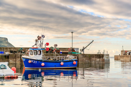 GARDENSTOWN, SCOTLAND - 2016 OCTOBER 22. Small blue fishing vessel inside Gardenstown Harbour.