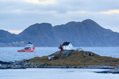 HAUGSHOLMEN LIGHTHOUSE, NORWAY - 2016 DECEMBER 05. Offshore vessel AHTS passing the Haugsholmen...