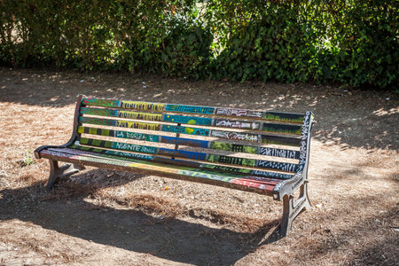 ROME, ITALY - 2014 AUGUST 17. Sitting bench in the park with grafitti painted.のeditorial素材