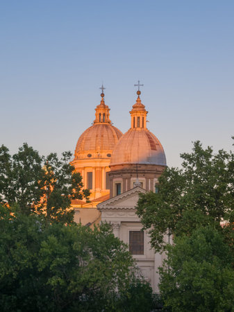 ROME, ITALY - 2014 AUGUST 17. Sunset light hit the twin church dome with kross on top.