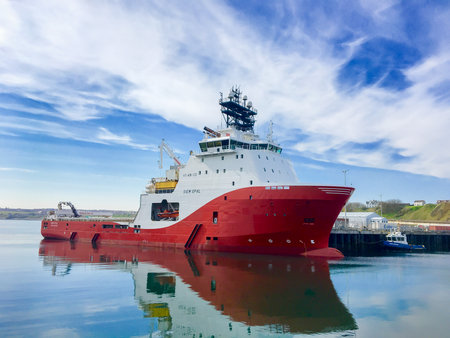 SCRABSTER, SCOTLAND - 2016 MAY 12. Offshore vessel AHTS Siem Opal moored inside harbour of Scrabster with blue skye and white clouds in the background.のeditorial素材