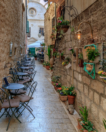 SIBENIK, CROATIA - 2017 AUGUST 18. Narrow walking path with chairs and tables outside the old city of Sibenik.のeditorial素材