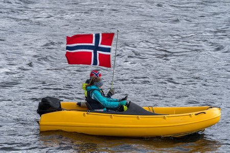 ULSTEINVIK, NORWAY - 2020 MAY 17. Two person on a small yellow boat celebrate the national day in Norway during covid19.のeditorial素材