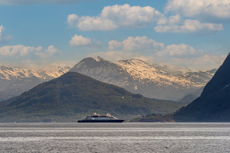 HAREID, NORWAY - 2020 MAY 25. Cruise vessel inside the fjord of Norway with snow capped mountains in the background.のeditorial素材