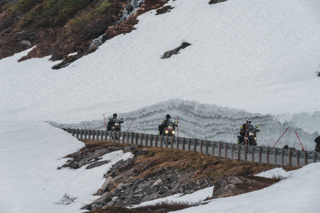 STRANDA, NORWAY - 2020 JUNE 21.People on motorcycles top of Geiranger in winter with snowcapped mountains in the backgroundのeditorial素材