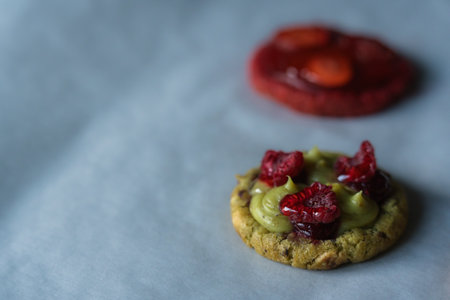 Homemade american cookie with pistachio and raspberries. Decorated with fresh raspberries, jam and pistachio cream. Copy space.の写真素材