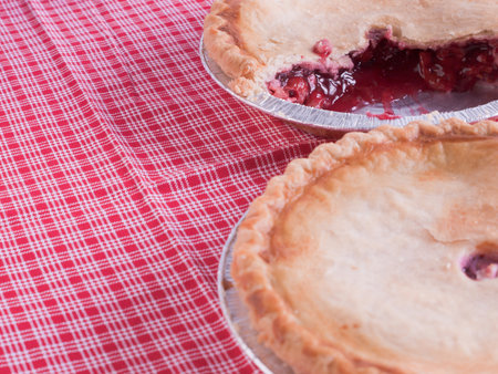 Cherry pie in baking tin with piece missing.の写真素材