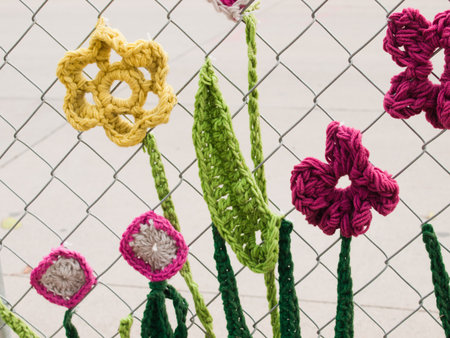 Construction fence covered with crocheted garden creatures like bugs and flowers by the Ladies Fancywork Society. Construction site of the Union Station in Denver, Colorado.のeditorial素材