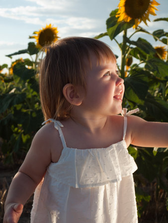 Little girl playing in sunflower field.の写真素材
