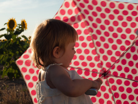 Little girl playing in sunflower field.の写真素材