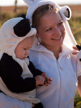 Toddler and her mother dressed up in cute costumes at the pumpkin patch.のeditorial素材