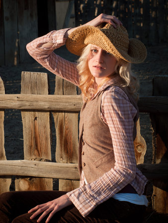 Country girl sitting by the fence.の写真素材