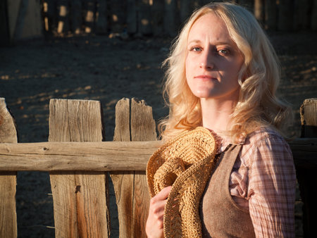 Country girl sitting by the fence.