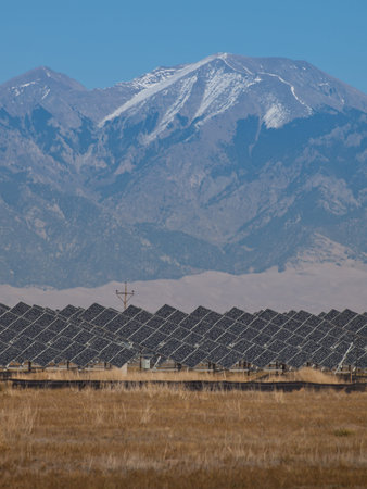 A series of large solar panels forms a symmetrical line at a power plant in the San Luis Valley of central Colorado. These panels utilize a tracking system to follow the sun, collecting its energy and using photovoltaic cells to transform the sunlight intのeditorial素材